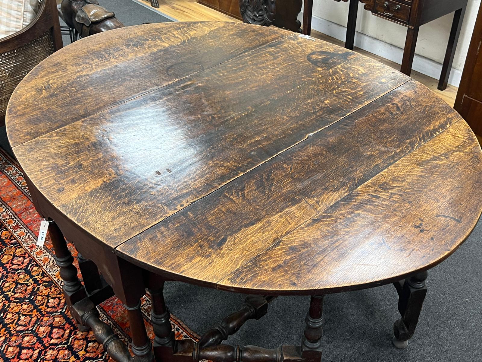 An 18th century oval oak gateleg dining table with turned under frame, width extended 146cm, depth 114cm, height 74cm